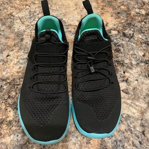 Black and teal Nike free tennis shoes.